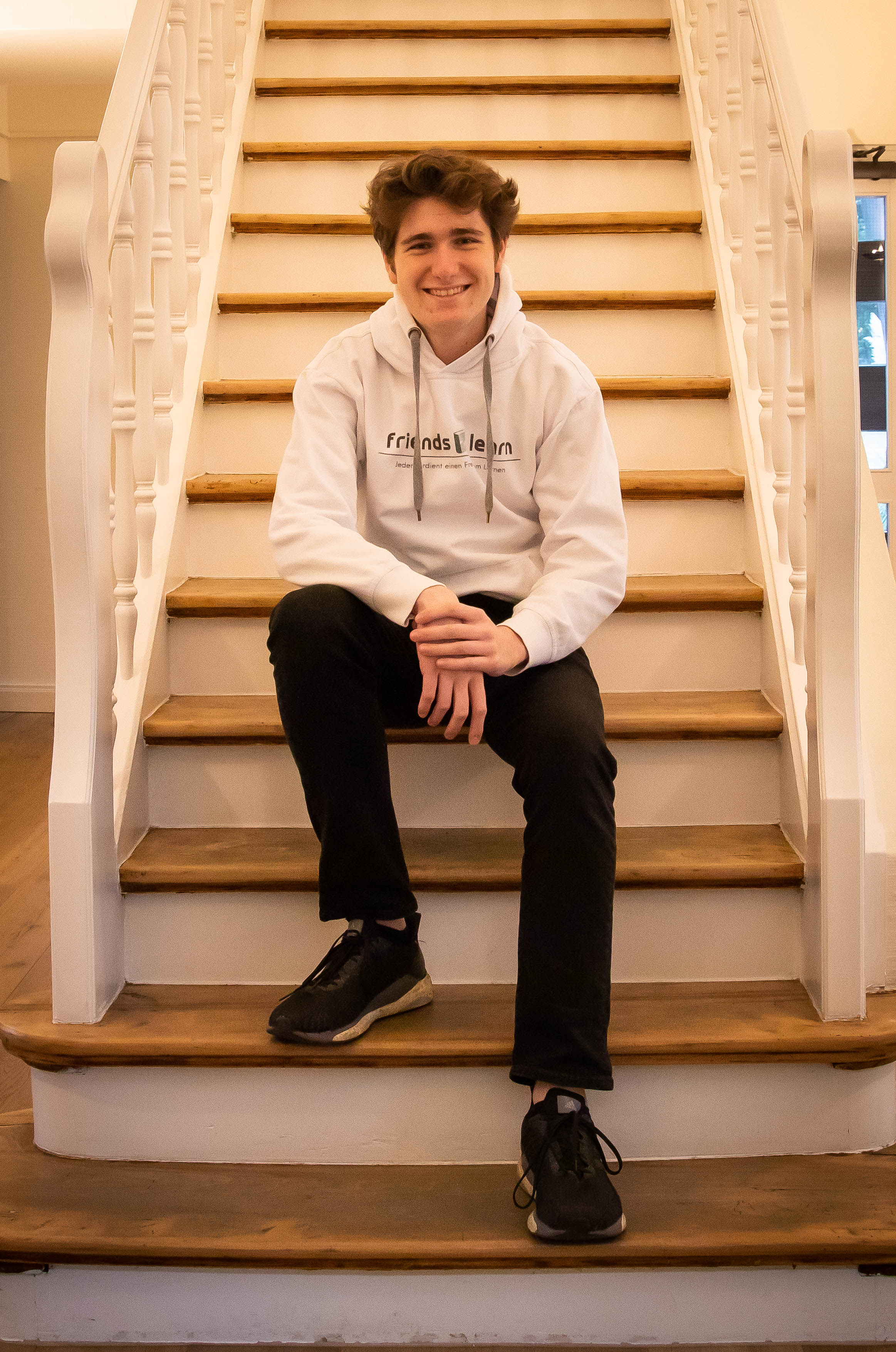 Niklas Gründker sitzt auf einer Treppe